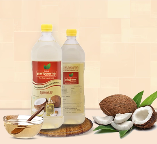 Two bottles of coconut oil with whole and split coconuts, plus a bowl of oil with a spoon inside